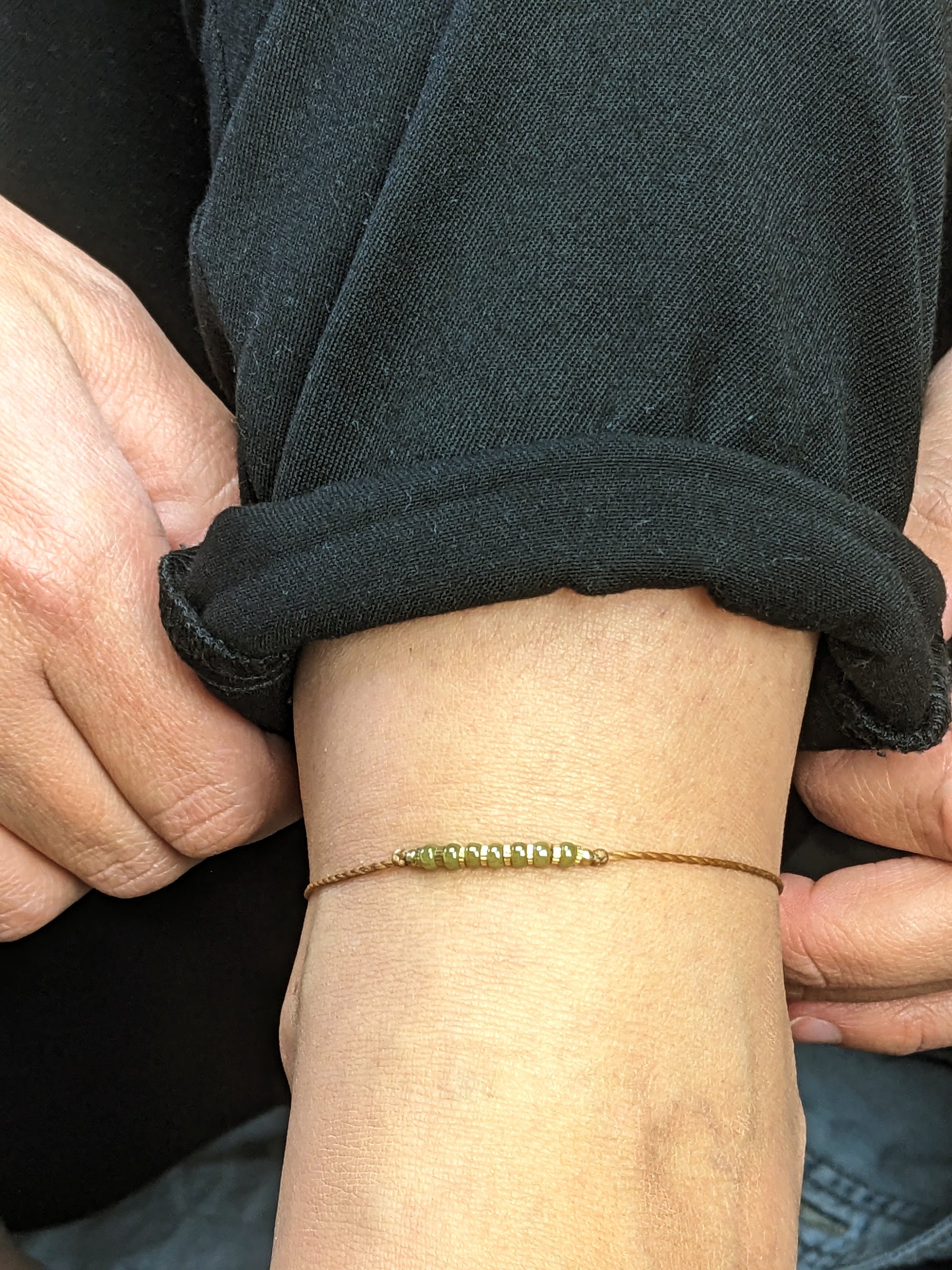 Braunes fußband mit grünen Glasperlen