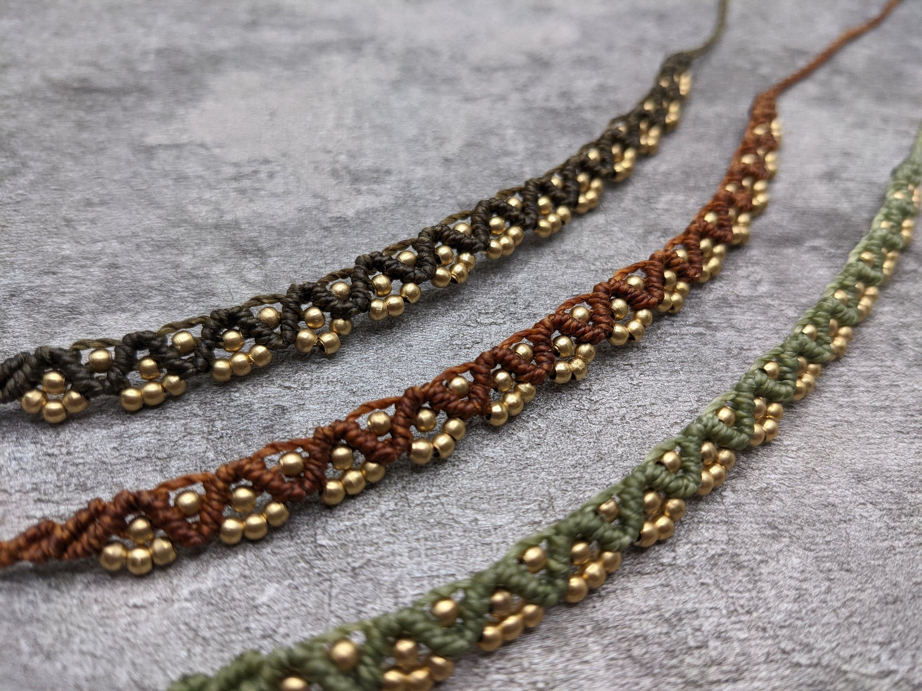 geknüpftes goldenes makramee fußband in wellenform im indian style