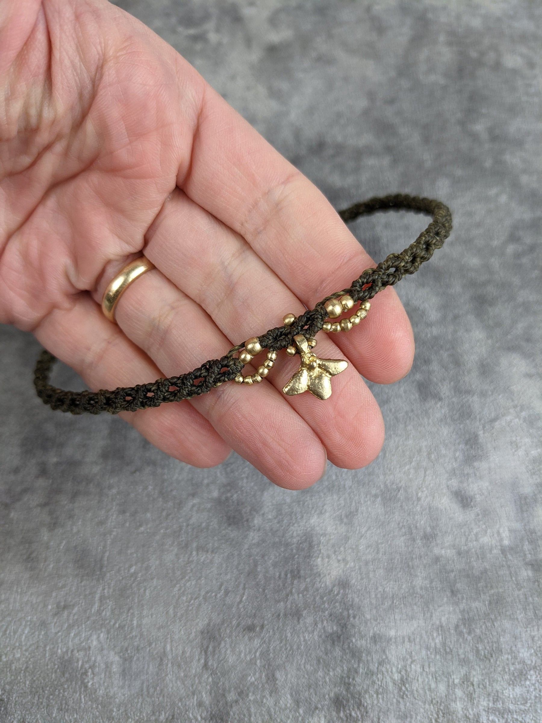 Makramee Tiara in dunklem grün mit goldener blüte in der mitte