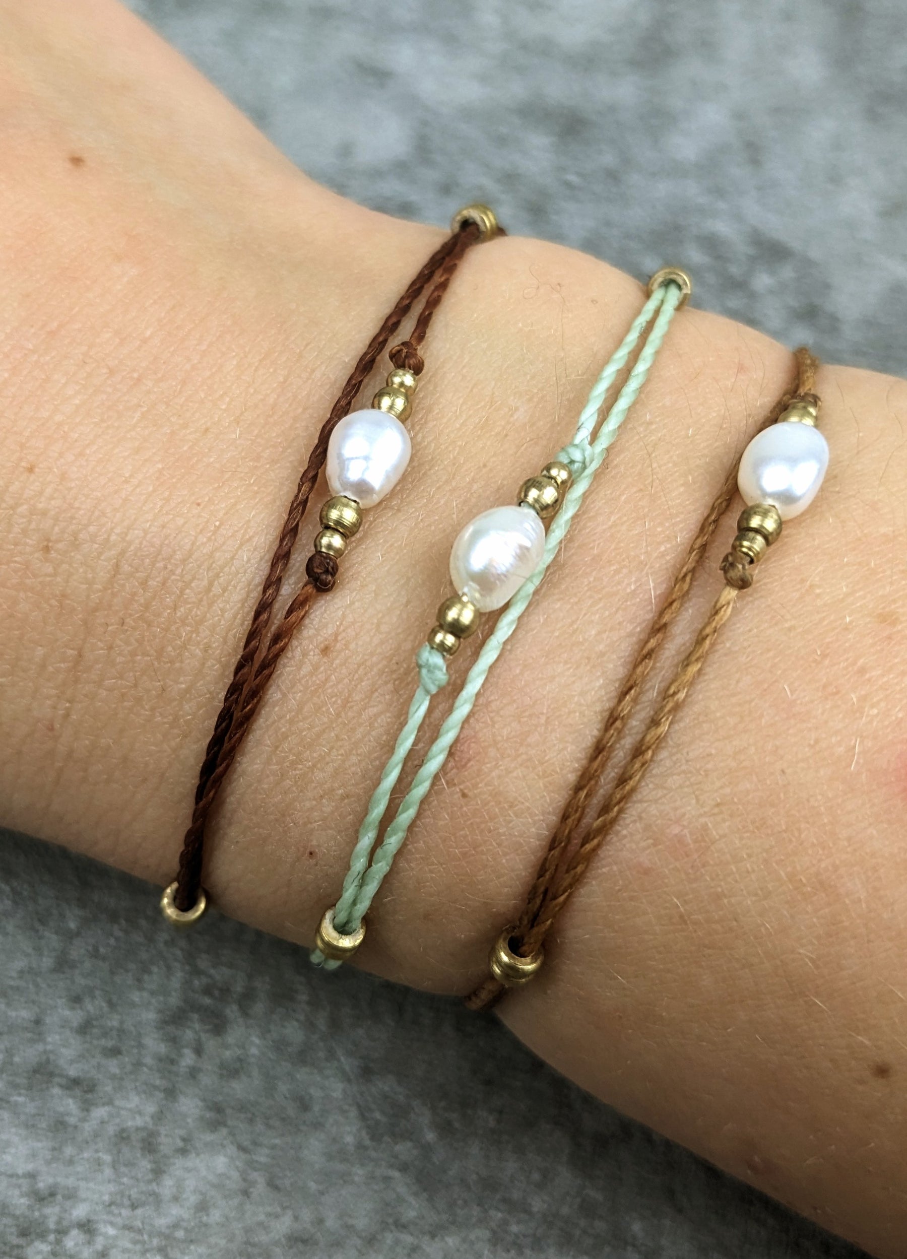 zartes süßwasser perlen armband mit weißer perle und buntem nylongarn, sowie kleinen messingperlen